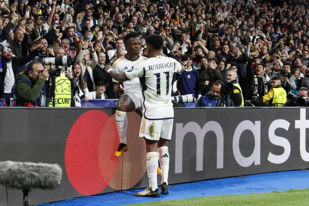 El delantero del Real Madrid Vinicius Junior (sentado) celebra su gol con Jude Bellingham tras marcar ante el Leipzig. Foto: EFE.