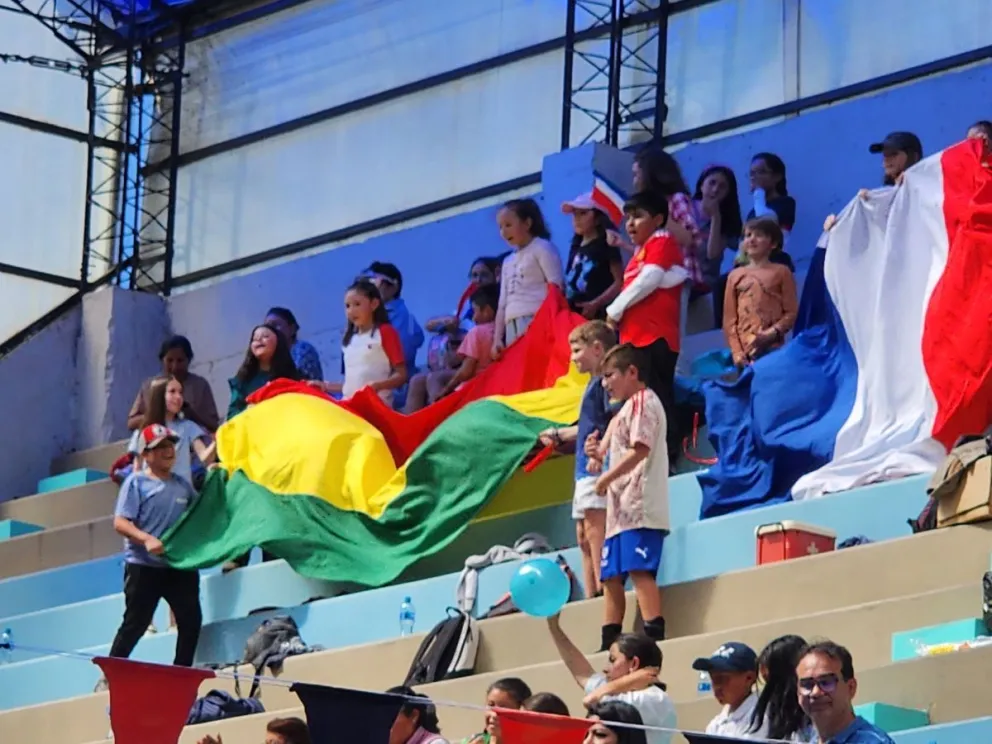 Varios niños con la tricolor nacional durante el relevo en la Piscina Municipal. Foto: Viceministerio de Deportes.