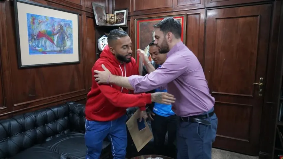 Eduardo Del Castillo, ministro de Gobierno (der.), abraza a "Rafinha" después de entregarle el documento de ciudadano boliviano. Foto: Eduardo del Castillo. 