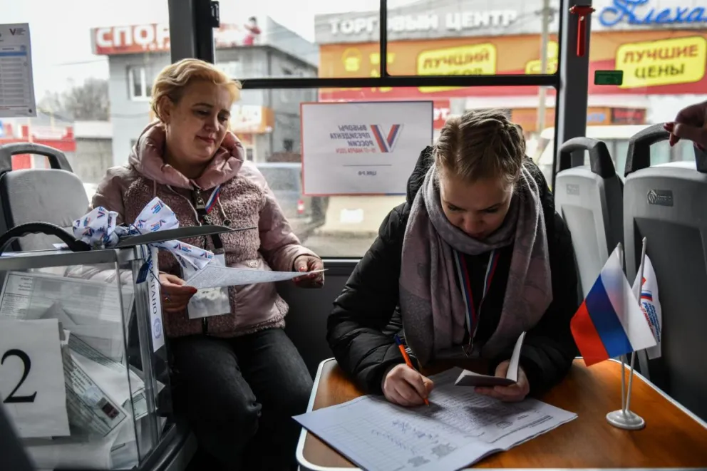 La población local emitió sus votos en la mesa electoral móvil del autobús durante las elecciones presidenciales en Donetsk, parte de Ucrania controlada por Rusia. Foto:EFE