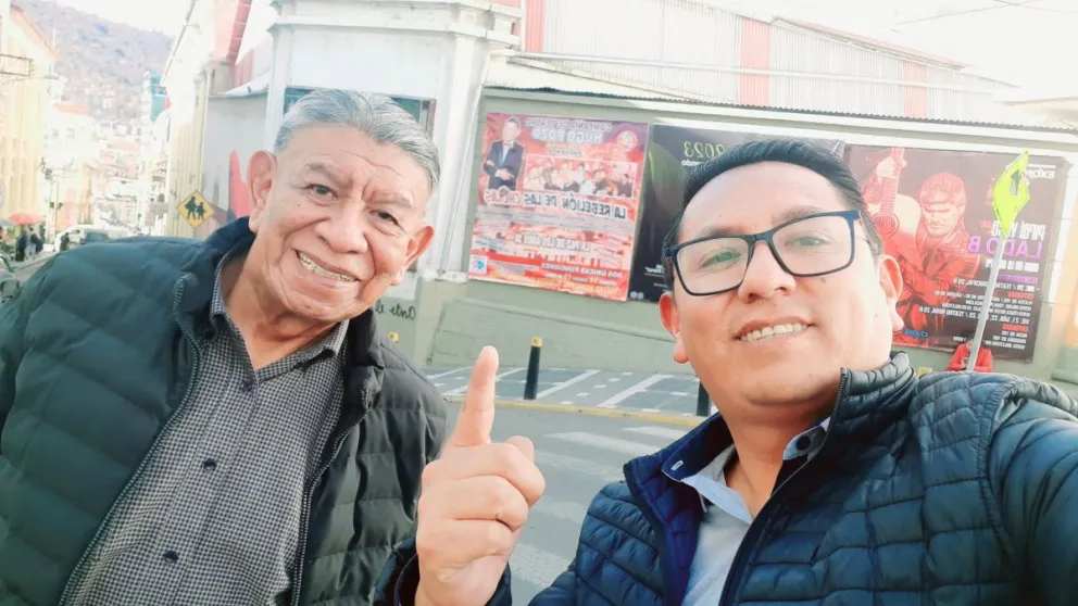 Padre e hijo posan frente a uno de los carteles promocionales de su obra. Foto: Guery Pozo