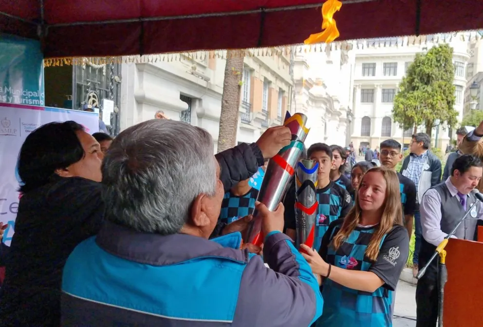 Trigosso (der.) hace la posta del Fuego Bolivariano con el alcalde Arias. Foto: Marcelo Avendaño.