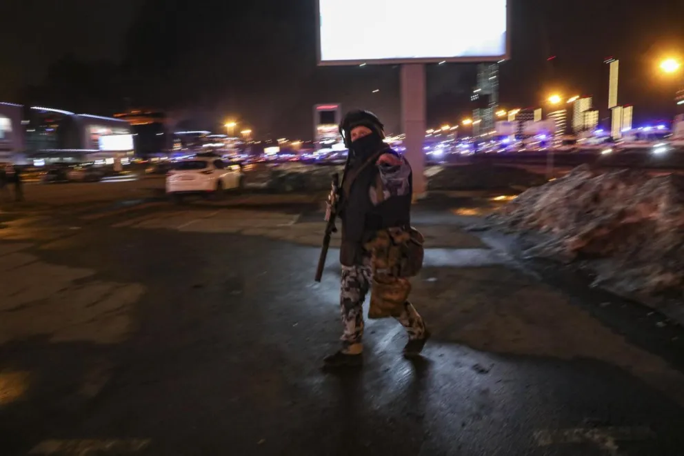 Un policía ruso camina cerca de la sala de conciertos Crocus City Hall en llamas. Foto: EFE
