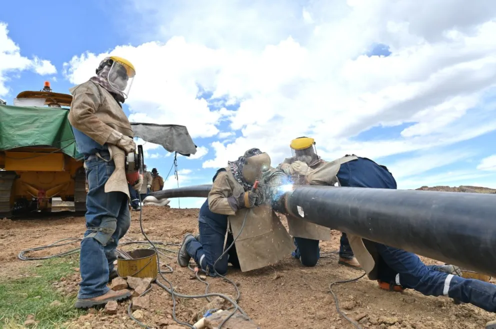 Trabajadores colocan una tubería adicional, paralela al ducto, que incrementa la capacidad de transporte.     Foto: YPFB.