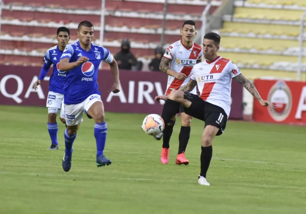 Sanguinetti (der.) domina el balón ante la marca de un rival de Millonarios, en el partido de 2020. Foto: Archivo Digital.