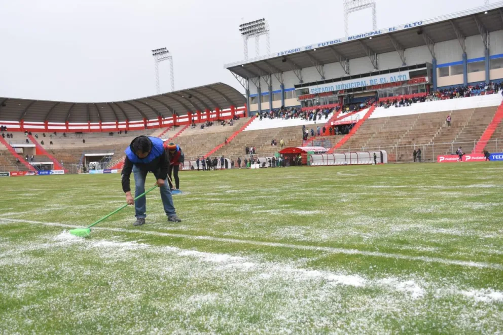 Con cepillos, el personal del estadio Municipal de El Alto retiró el exceso de granizo. Foto: APG