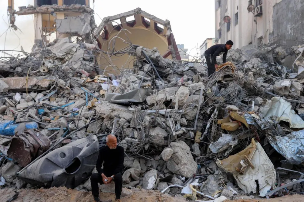 Dos palestinos inspeccionan los escombros cerca del hospital, después de que el ejército israelí se retirara tras una operación militar de dos semanas. Foto: EFE