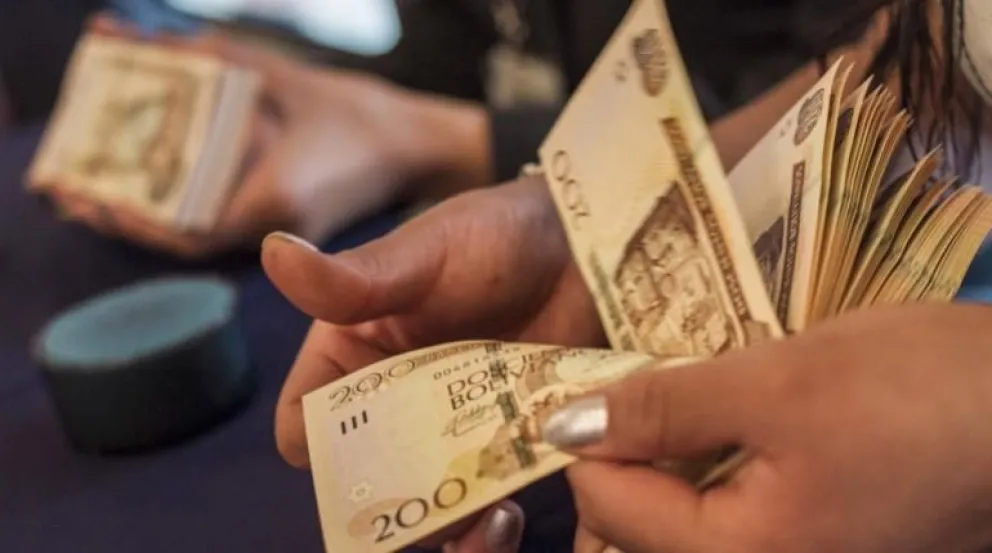 Una mujer cuenta dinero en corte de 200 bolivianos. Foto: ABI