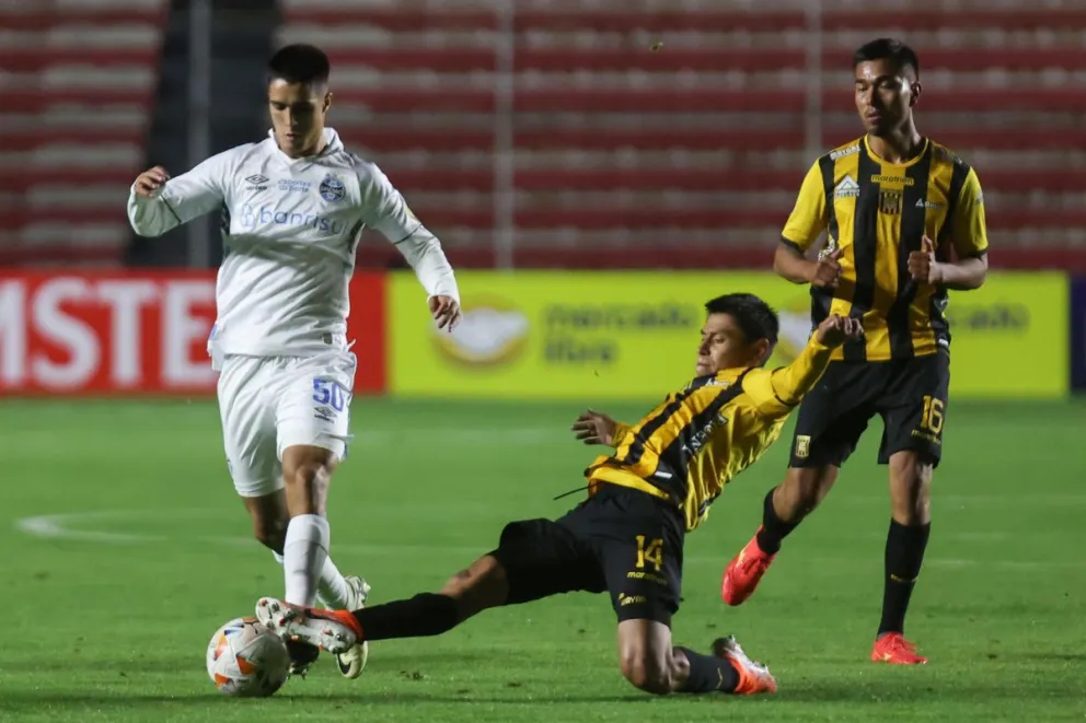 Wayar (centro) sale a la marca de Chemon, jugador de Gremio. Metros atrás aparece Cuéllar. Foto: EFE