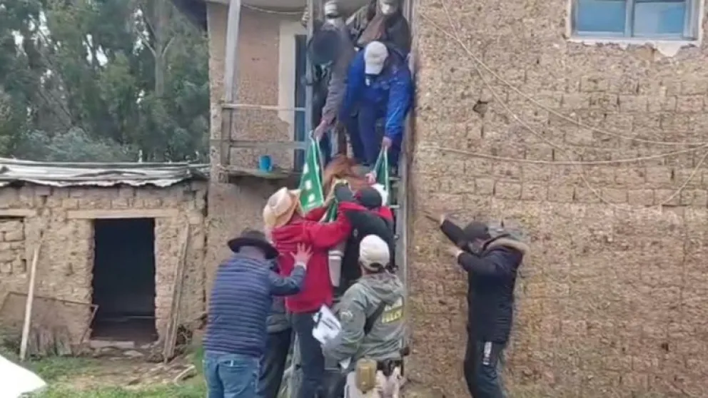 Efectivos de la Policía y vecinos bajan el cadáver de la mujer de 74 años. Foto: Radio Kollasuyo