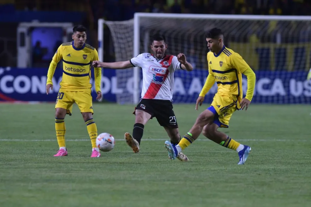 Baldomar (centro) trata de quitar la pelota a dos jugadores de Boca. Foto: APG.