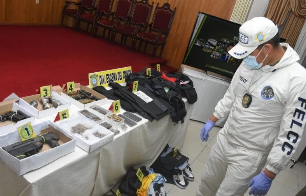 Un policía muestra las armas que portaban los acusados, quienes fueron identificados como integrantes del Tren de Aragua. Foto: APG