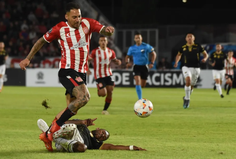 Enoumba, en el piso, le comete la falta a un jugador de Estudiantes y luego verá la roja. Foto: APG