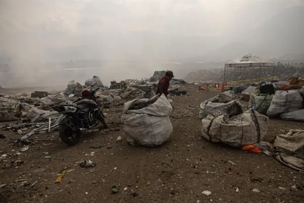 Un hombre arrastra una bolsa con material reciclable este 10 de abril de 2024 en un vertedero afectado por incendios forestales al sur de Ciudad de Guatemala. Foto: EFE/ David Toro
