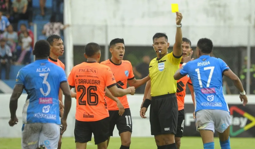 Dilio Rodrígurez muestra una amarilla en el partido del domingo. Foto: APG.