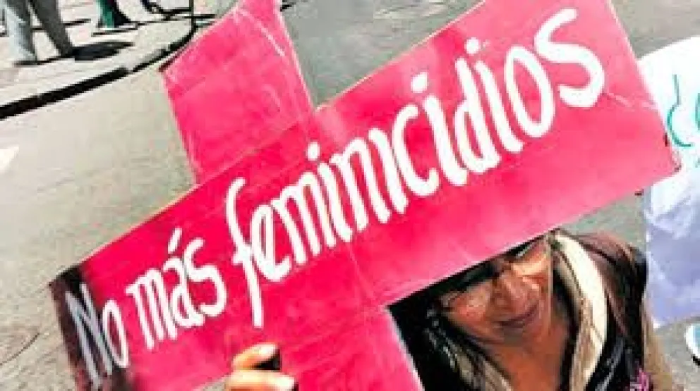 Una mujer muestra un cartel con el mensaje de "No más feminicidios". Foto: ABI