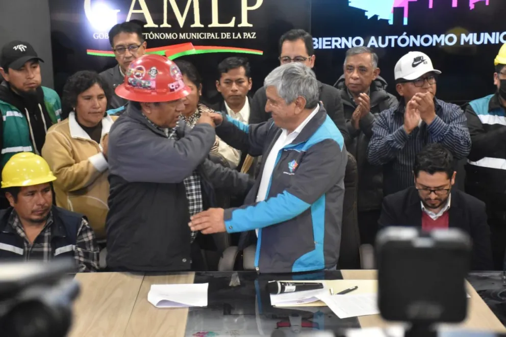 Dirigente de la COD y el alcalde Iván Arias se dan un abrazo luego de firmar el acuerdo. Foto: Gobierno Municipal de La Paz.