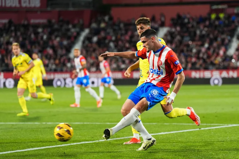 El defensa del Girona Miguel Gutiérrez (dcha) golpea el balón durante el partido de la jornada 32 de LaLiga EA Sports. Foto: EFE