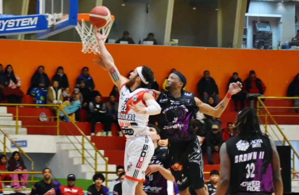 Un jugador de Nacional encesta la pelota ante un rival de Kinwa. Foto: Nacional Potosí.