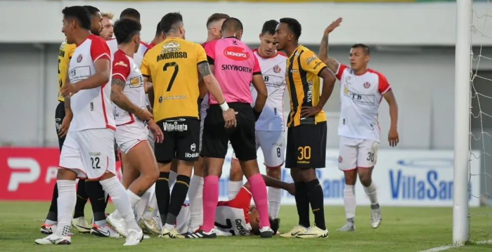 Jugadores de FC Universitario y The Strongest reclaman al árbitro Javier Revollo por un cobro. Foto: APG.