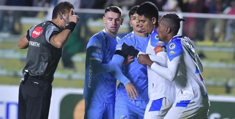 Gery Vargas (izq.) con jugadores de Bolívar y San Antonio en el partido del 18 de abril en La Paz. Foto: APG 