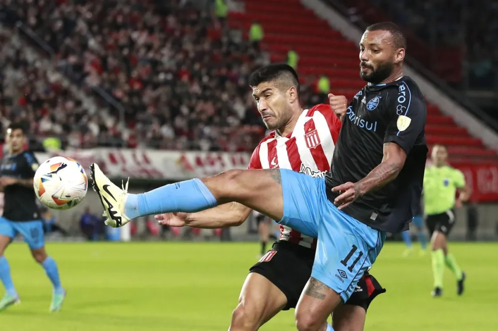 Lollo de Estudiantes disputa el balón con Geraldino de Gremio, en el lance de esta noche. Foto EFE