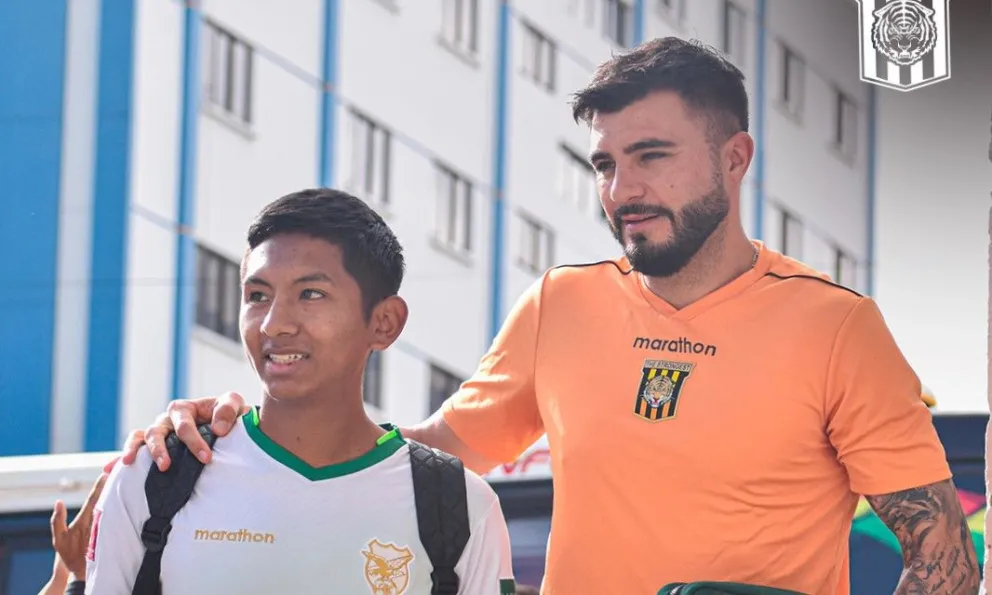 Enrique Triverio posa con un hincha en uno de los últimos viajes del Tigre. Foto: club The Strongest