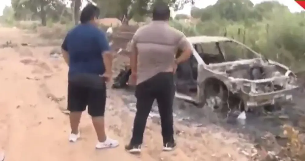 El propietario del auto mira los restos quemados del mismo. Foto: Captura de video