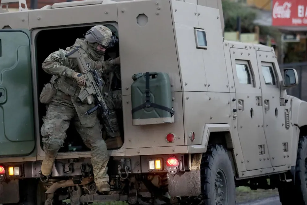 Personal militar patrulla en la ruta P72S, donde se llevan a cabo los peritajes a un vehículo incendiado que dejó tres muertos este sábado. Foto: EFE