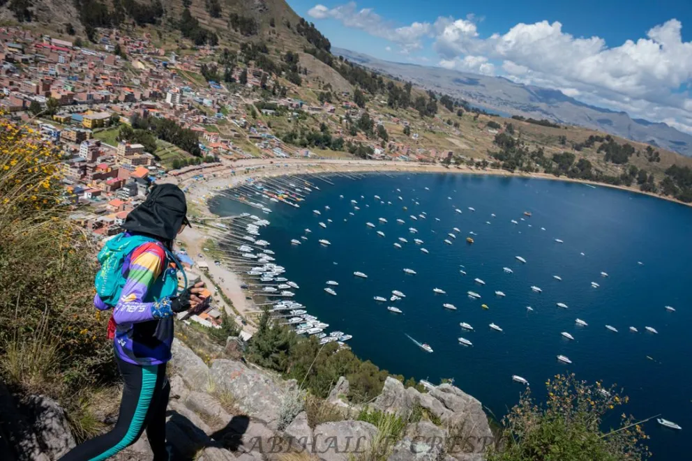 Una atleta en plena bajada durante un tramo del trayecto. De fondo el lago Titicaca. Foto: Skyrunning Bolivia.