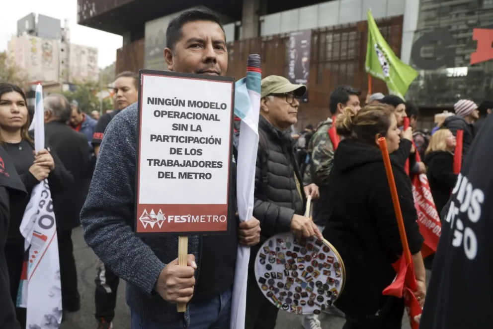 Personas sostienen letreros alusivos al Día del Trabajo en Santiago, Chile. Foto: EFE
