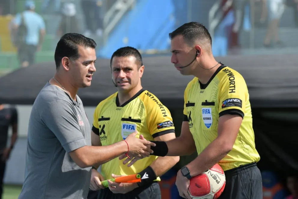 El entrenador Pablo Godoy saluda al árbitro chileno del partido. Foto APG
