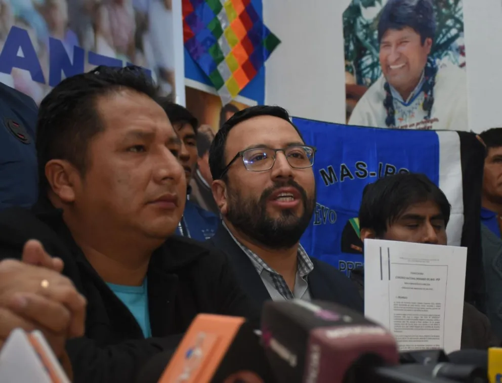 Diego Jiménez (centro), delegado del MAS ante el TSE muestra el estatuto orgánico de su partido. Foto: APG