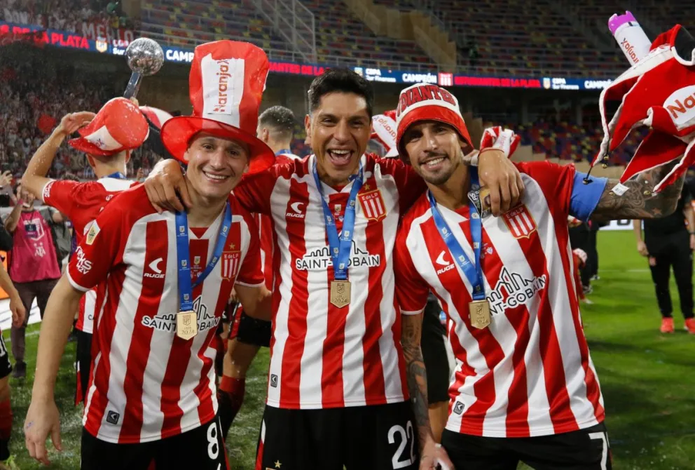 Enzo Pérez (centro) festeja el título de Estudiantes con dos de sus compañeros. Foto: club Estudiantes de La Plata