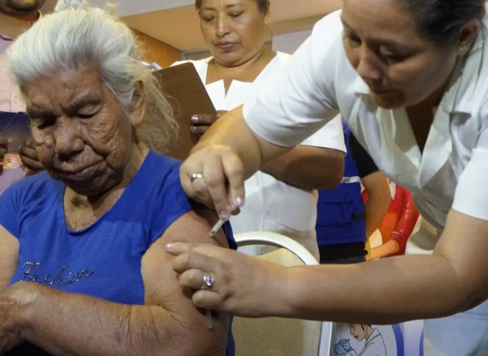Una enfermera vacuna contra la influenza a una mujer de la tercera edad. Foto. Ministerio de Salud.