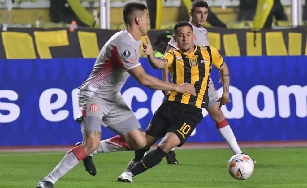 El atigrado Michael Ortega trata de superar la marca de un rival de Estudiantes. Foto: APG