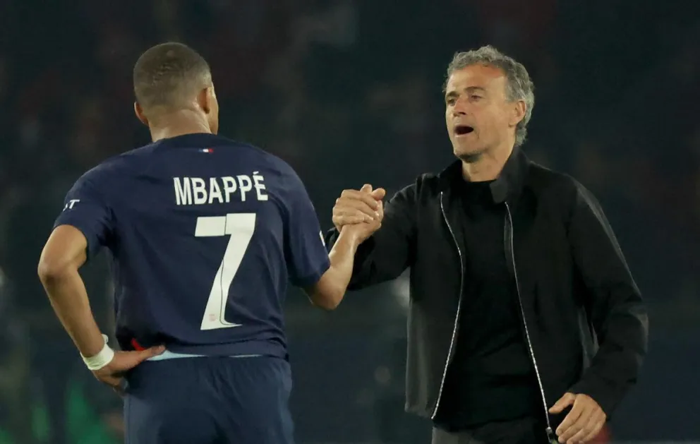 Kylian Mbappé y el técnico Luis Enrique se dan la mano en un partido anterior. Foto: EFE