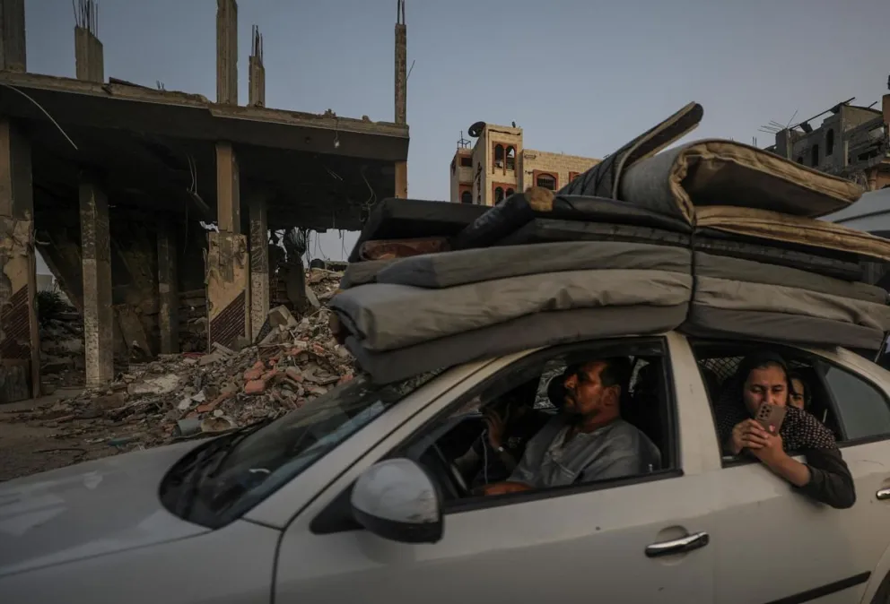 Palestinos escapan de Rafah en medio de edificios destrozados. Foto: EFE