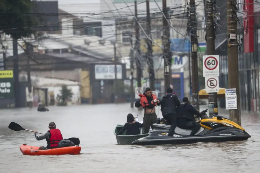 Miembros de la Policía realizan un operativo en las calles inundadas en la región del centro de Porto Alegre. Foto: EFE