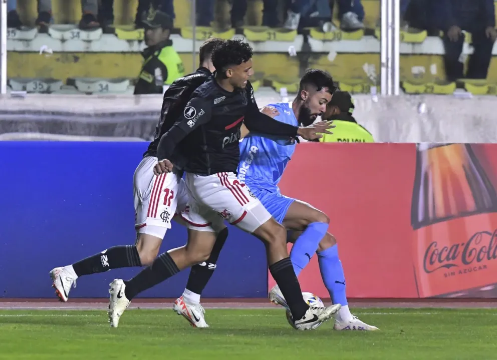 Sávio se enfrenta a dos jugadores de Flamengo en La Paz. Foto: APG.