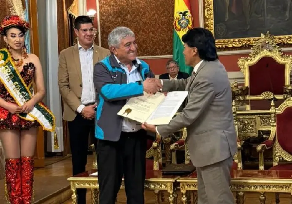 El alcalde de La Paz, Iván Arias, entrega el reconocimiento al presidente de la Asociación de Conjuntos Folklóricos del Gran Poder, Gregorio Carrillo. Foto: AMUN 