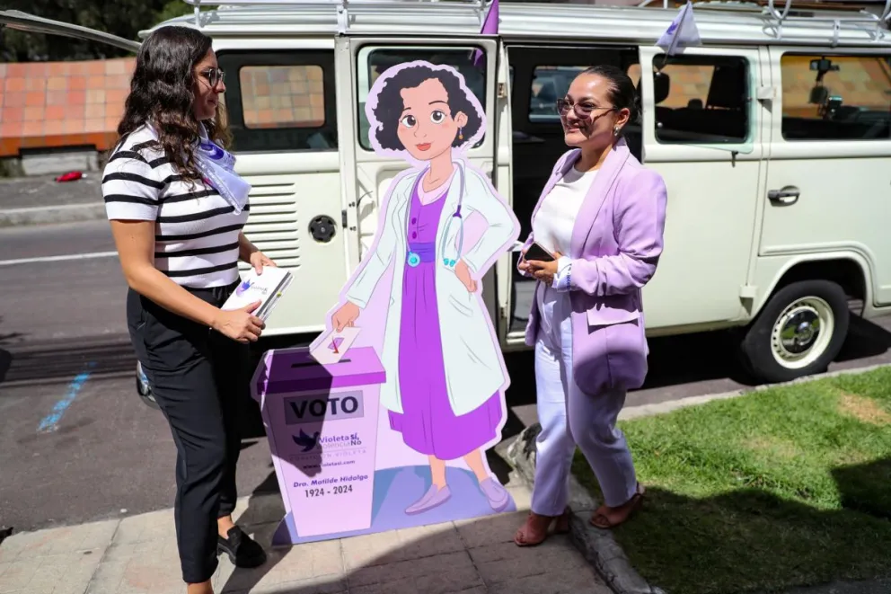 Dos mujeres promueven la iniciativa de la 'Kombi Violeta' este lunes en Quito (Ecuador). Foto: EFE