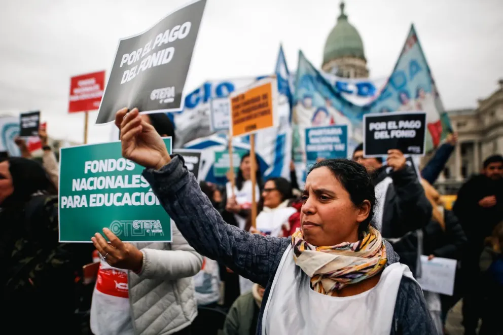 Una manifestante sostiene un cartel con consignas durante la huelga general de educadores, en la Plaza del Congreso, este jueves, en Buenos Aires (Argentina). Foto: EFE