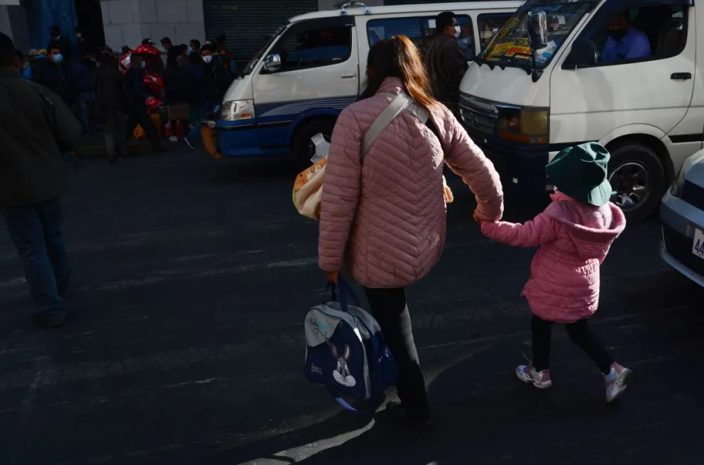 Una mamá lleva a su hija a la escuela. Foto: ABI