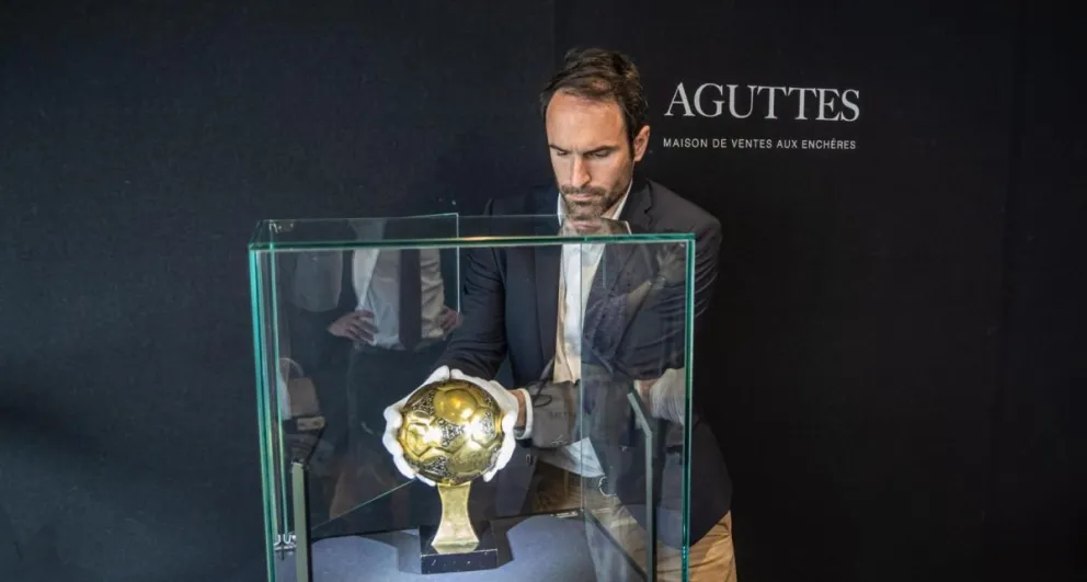 Francois Thierry instala en la vitrina el Balón de Oro que ganó Maradona en 1986. Foto: EFE.