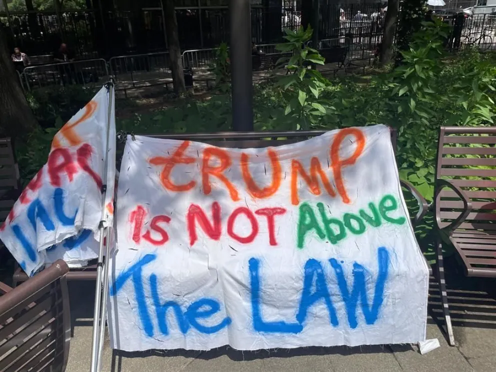 Un cartel que dice "Trump no está por encima de la ley" durante una concentración a las afueras del juzgado. Foto: EFE