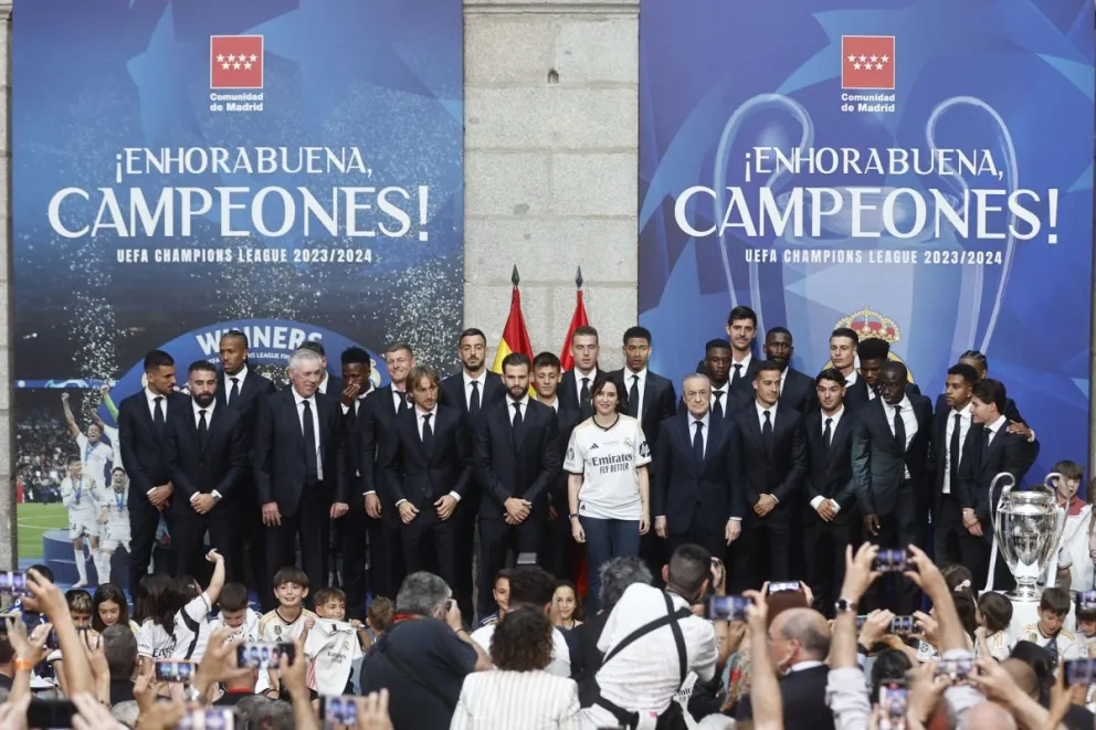 Jugadores y cuerpo técnico del Real Madrid posan junto a la presidenta de la Comunidad, Isabel Díaz Ayuso, en su visita a la Real Casa de Correos. Foto EFE