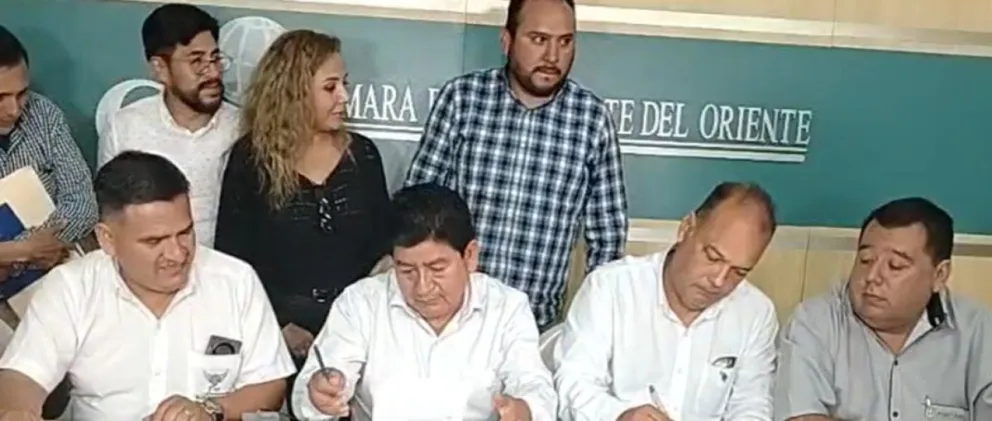 El ministro de Obras Públicas, Édgar Montaño, firma el acuerdo con sectores de transportistas en Santa Cruz. Foto. Unitel