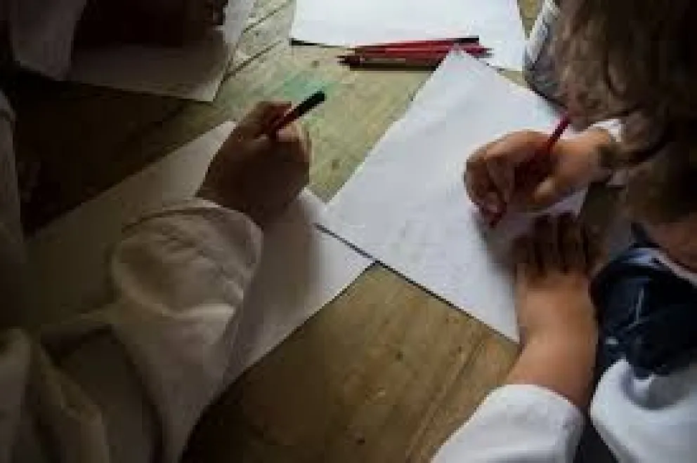 Una foto referencial de niñas y niños escribiendo cartas.  Foto: Facebook