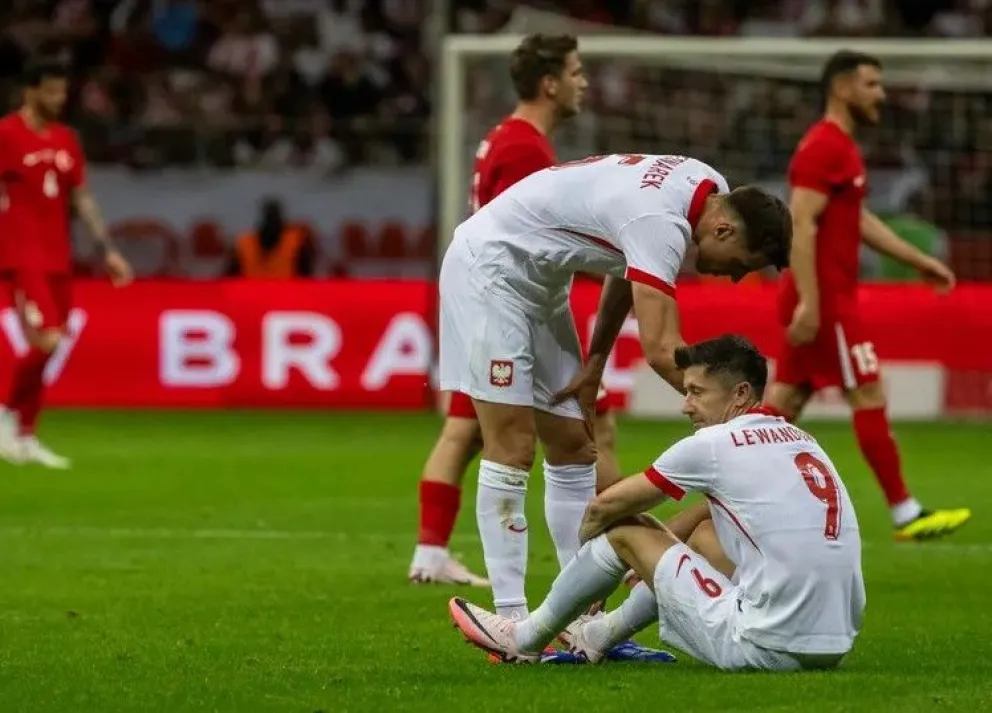 Robert Lewandowski es atendido por unos de sus compañeros tras lesionarse en el partido frente a Turquía.